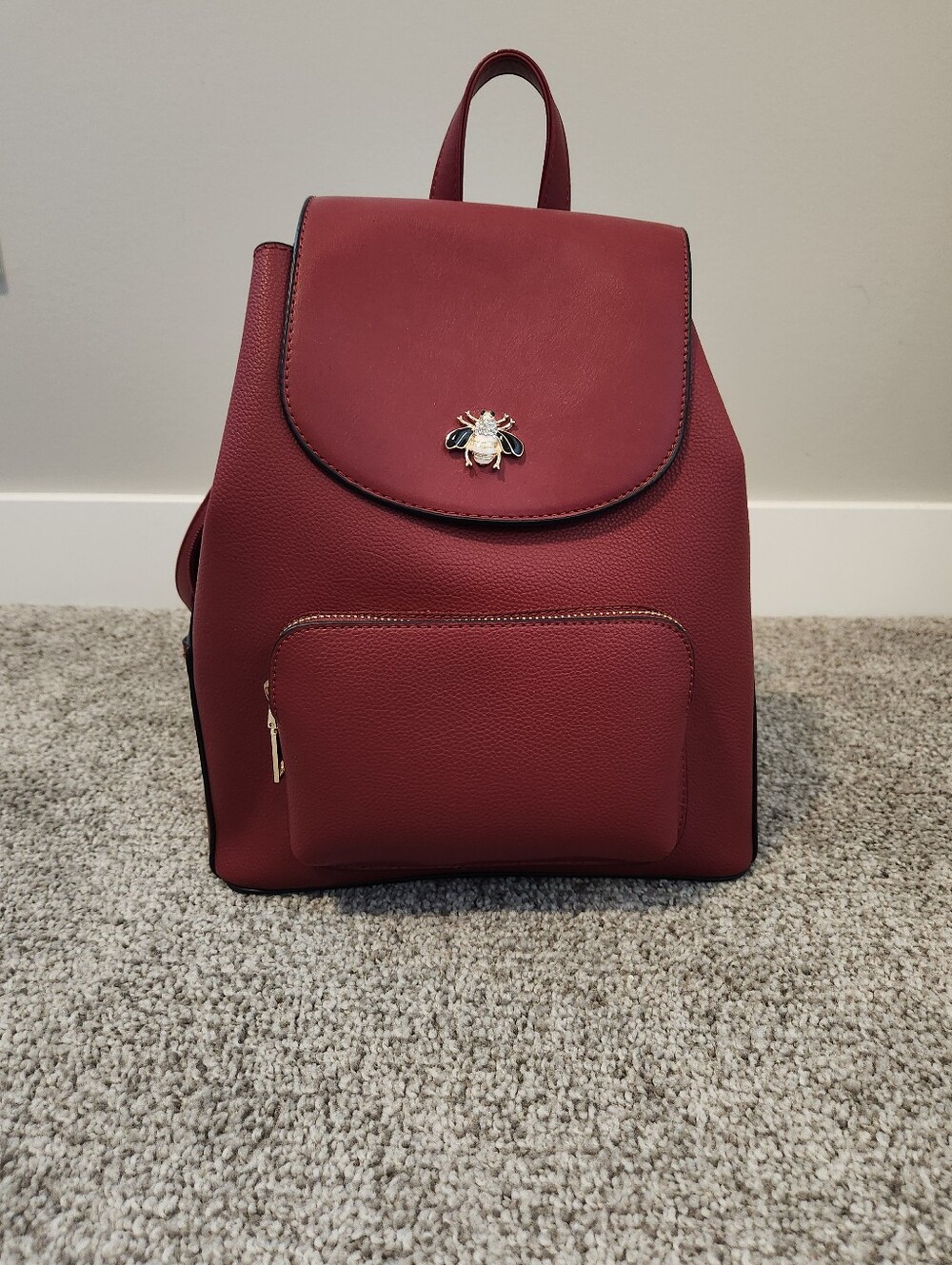 Red faux leather backpack purse new without tags with bee snap closure.